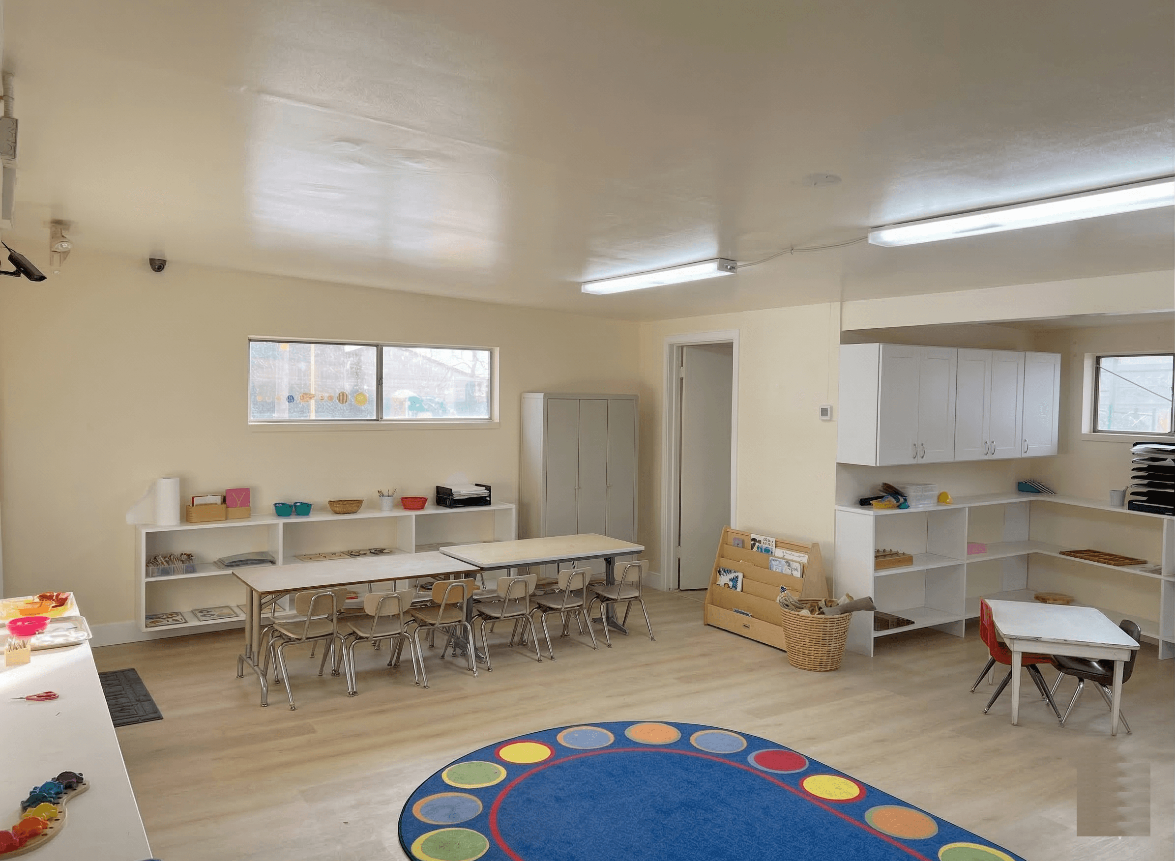 Preschool classroom with tables and learning rug